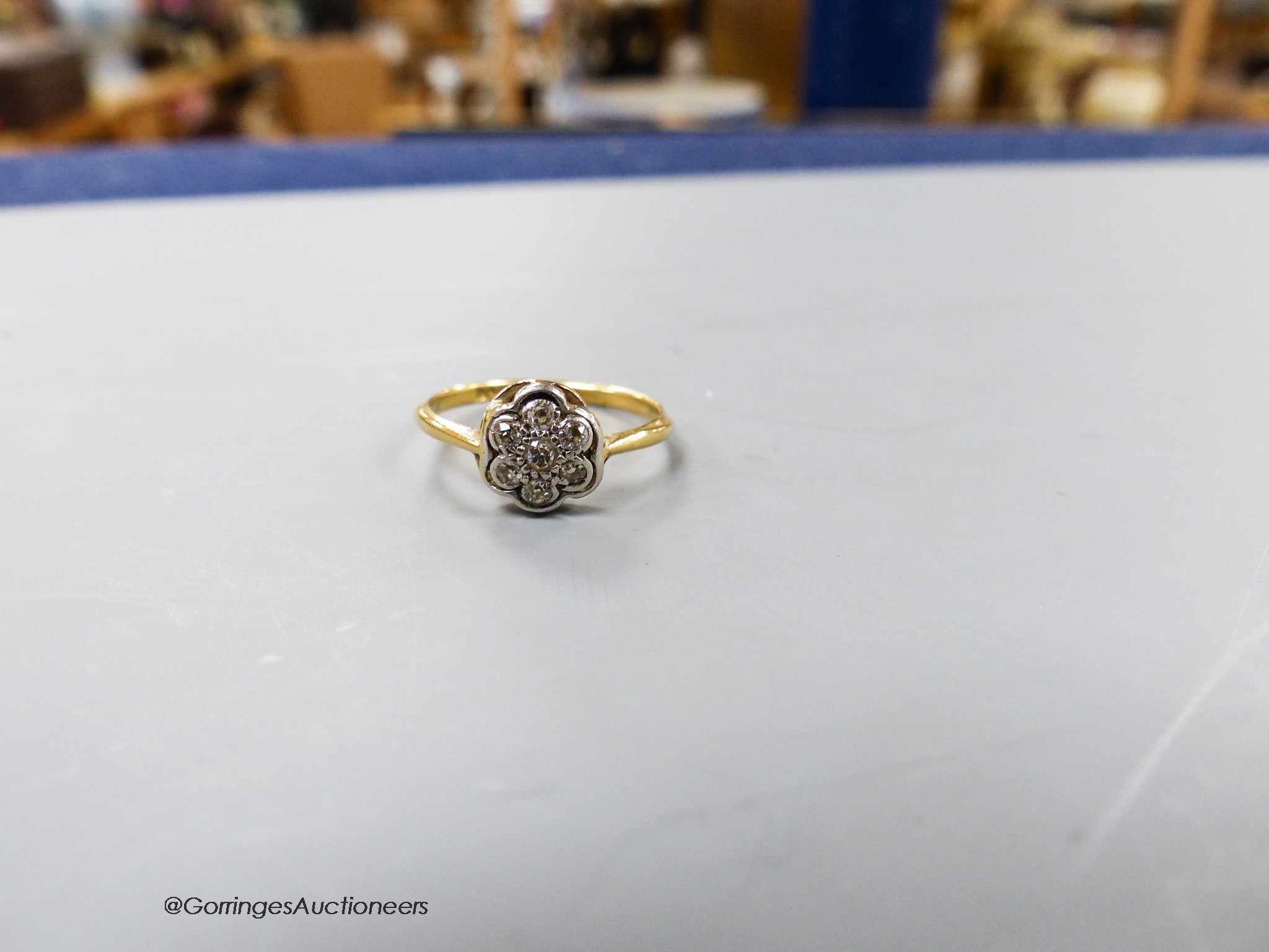 A 1920's 18ct & plat set circular diamond cluster ring, size M/N, gross 1.9 grams.